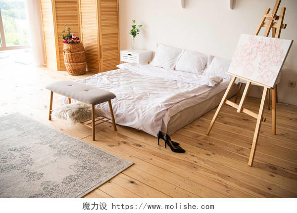卧室配有白色毯子和枕头画架床头柜地毯房间铺垫和木地板上的黑色高跟鞋